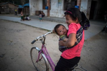 8.The IDP girl was carrying her brother while she was riding the bicyclePa Kahtawng Camp in MaiJaYang township,Kachin State on June,4,2016.Photo NyanZayHtet