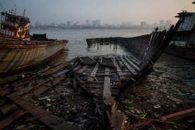 The old wooden boat lay down at the Yangon River Bank